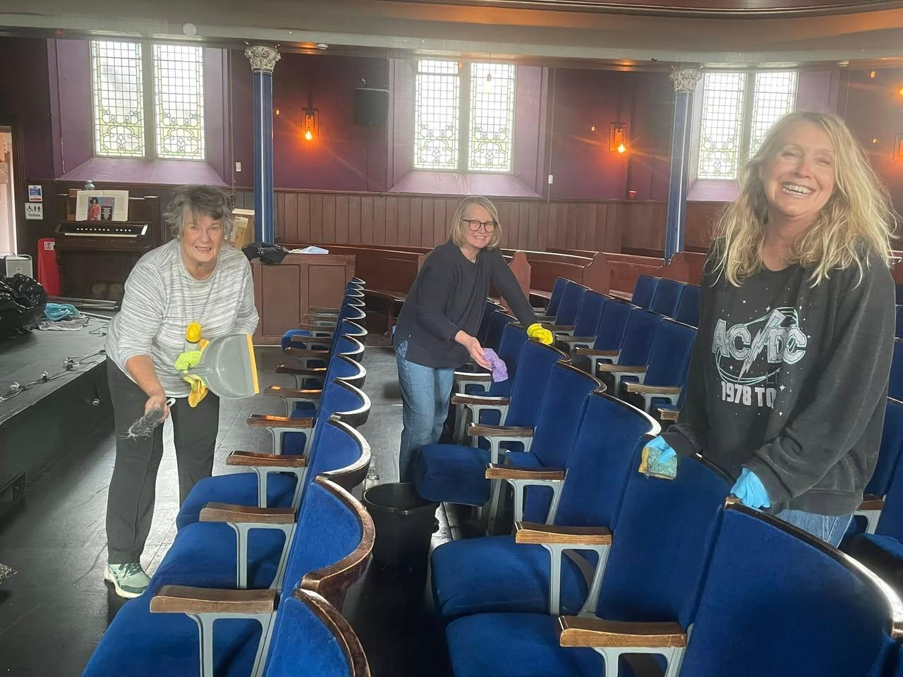 Volunteers cleaning the auditorium seats inside The Tower